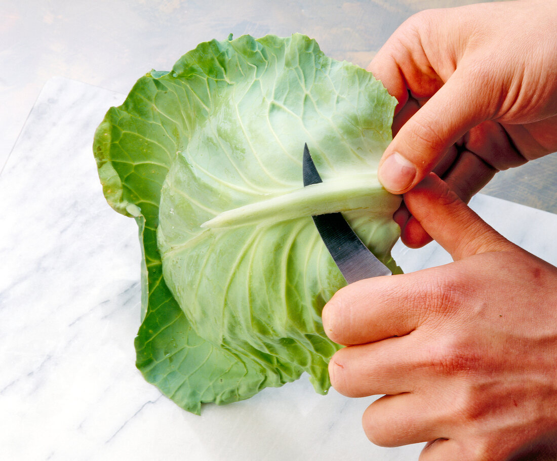 Removing veins of cabbage leaf with knife