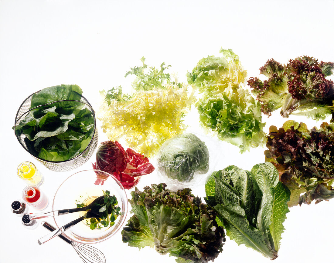 Various leafy greens vegetables with oil and whisk