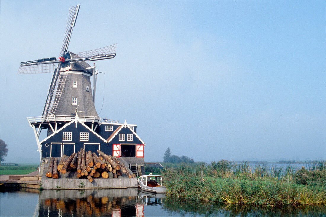 View of windmill on the lake against blue sky