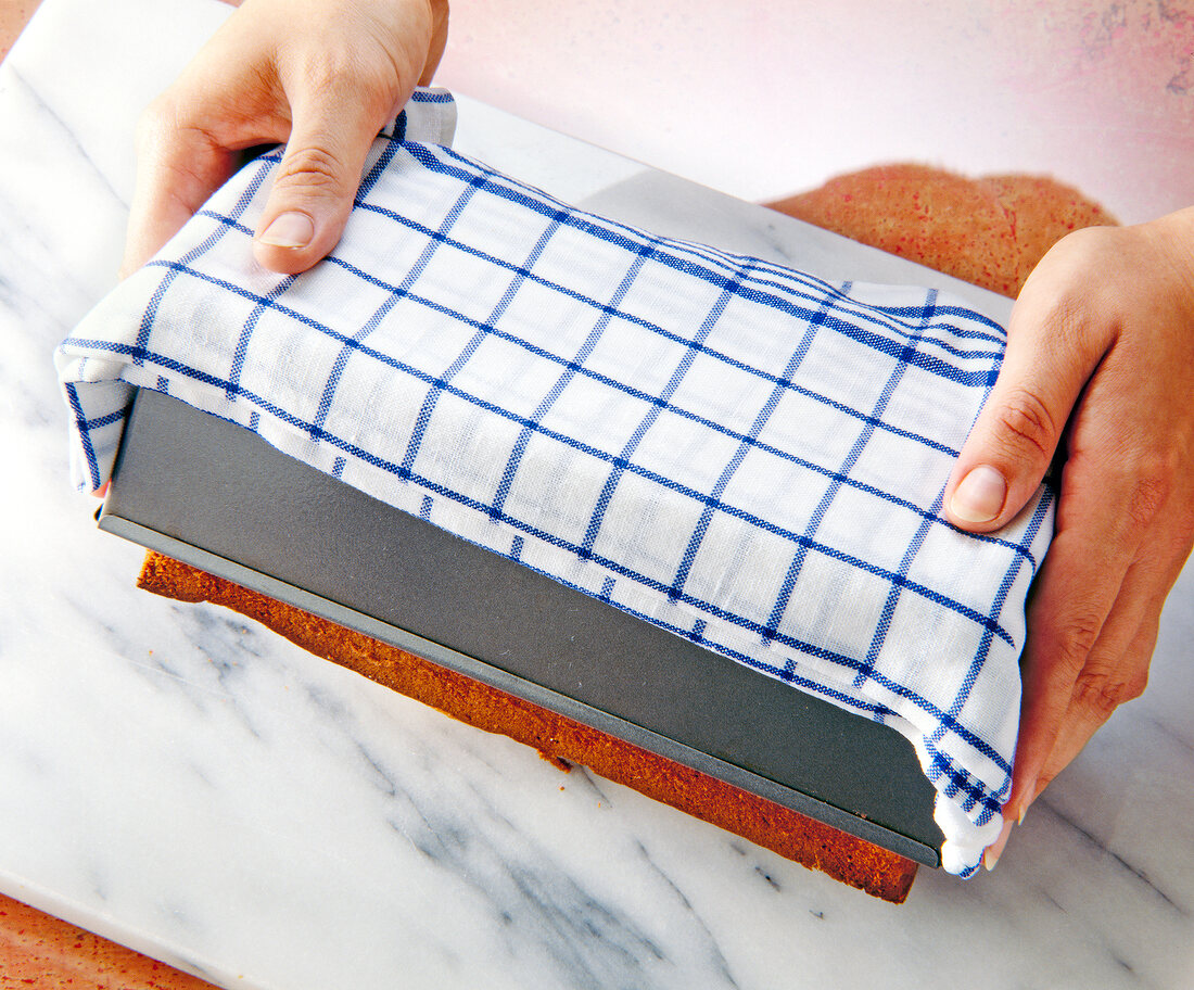 Removing cake from baking pan with wet towel