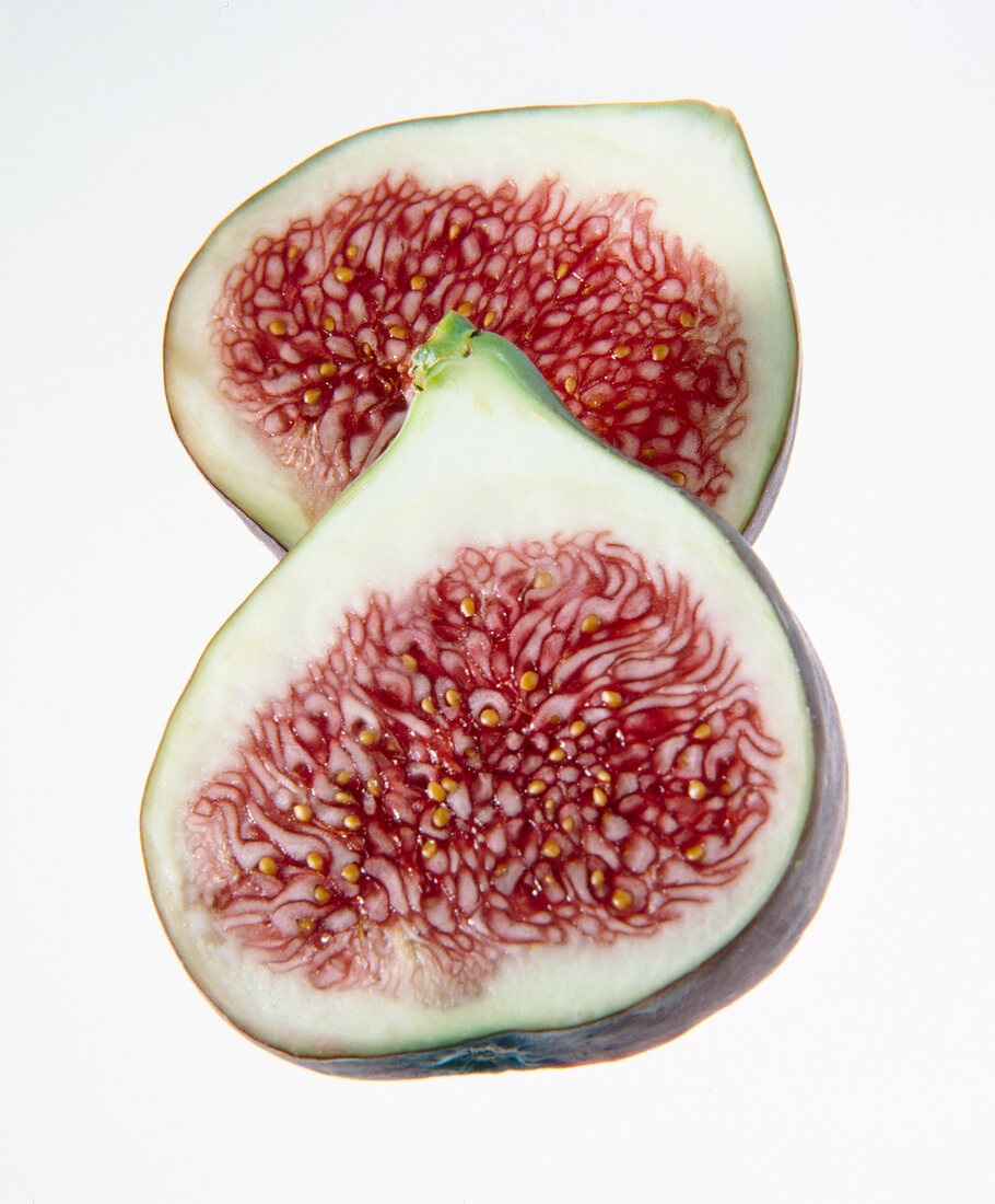 Close-up of two halved figs on white background