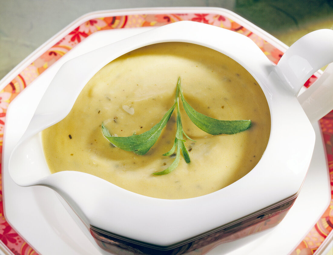 Celery on apple mustard sauce with tarragon in white gravy boat