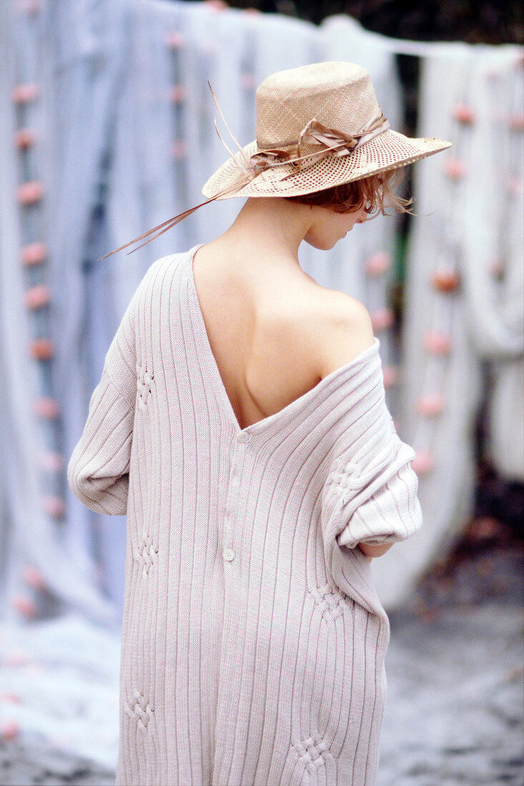 Rear view of woman wearing big v-necked sweater and hat