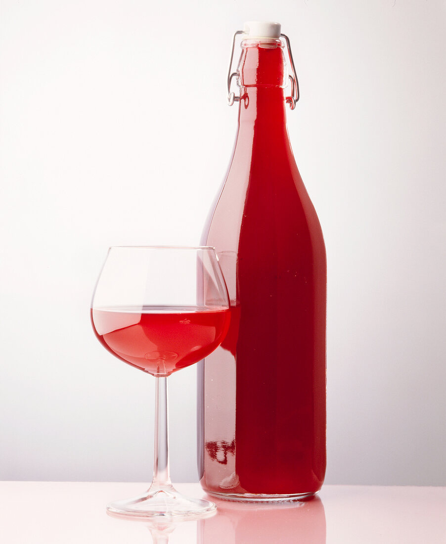 Schwarzer Johannisbeer-Saft in Flasche und Glas.