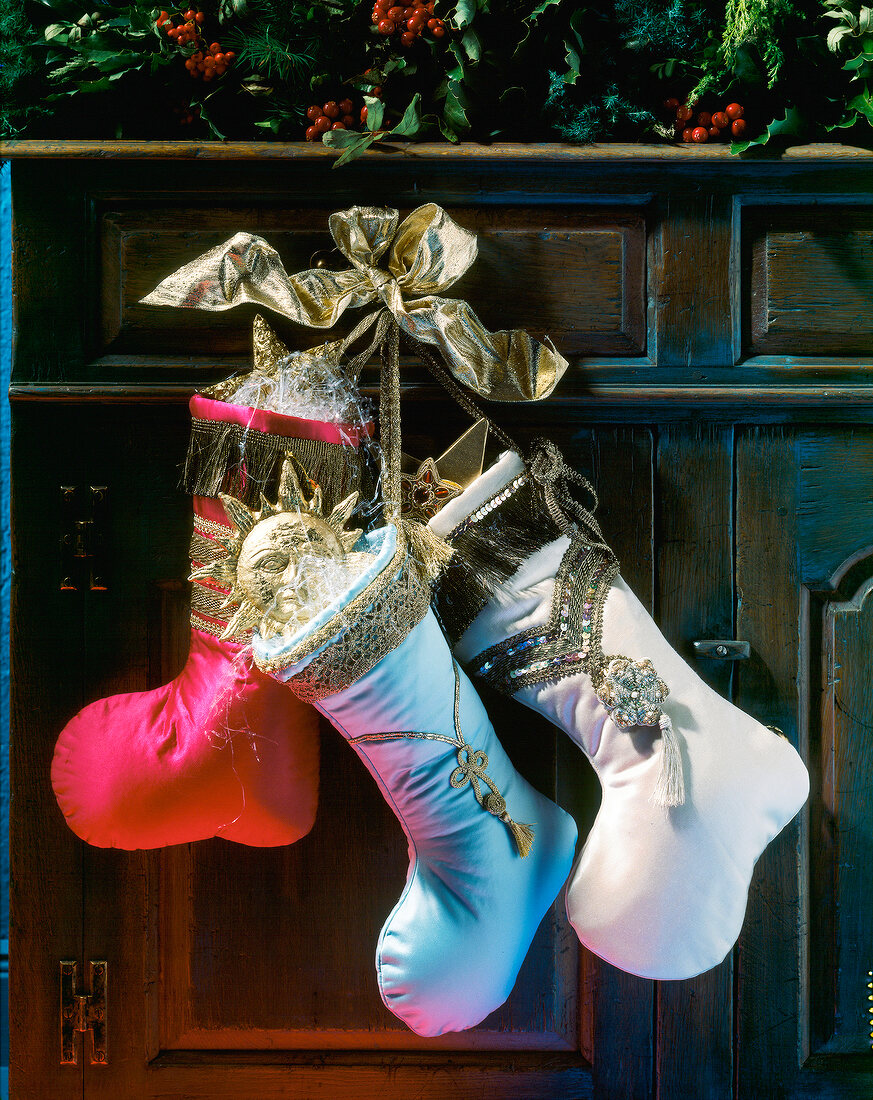 Close-up of red, blue and white stockings decorated with gold ribbon bows