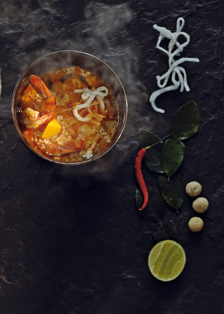 Hot shrimp and coconut soup in bowl, overhead view