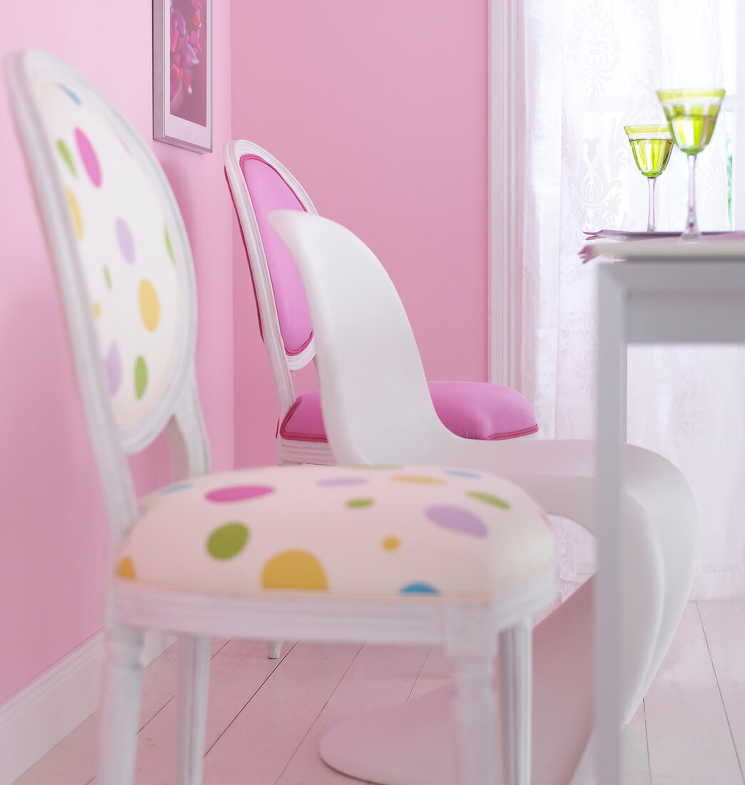White, pink and spotted chairs in dining room