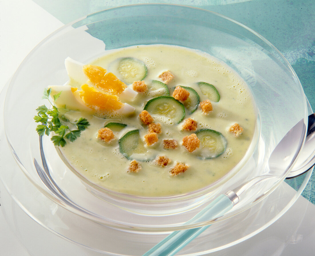 Zucchini soup with croutons and eggs in bowl