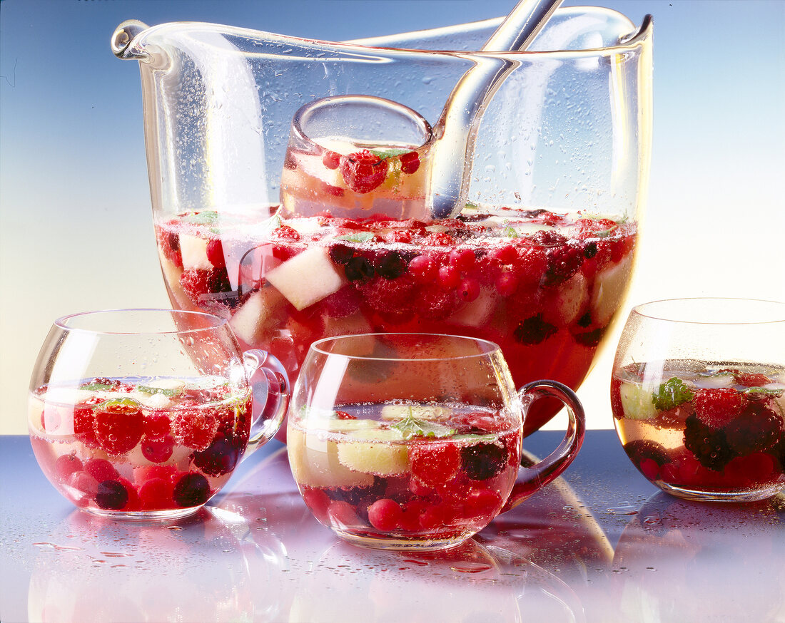 Large glass jar and glasses with berries and melon