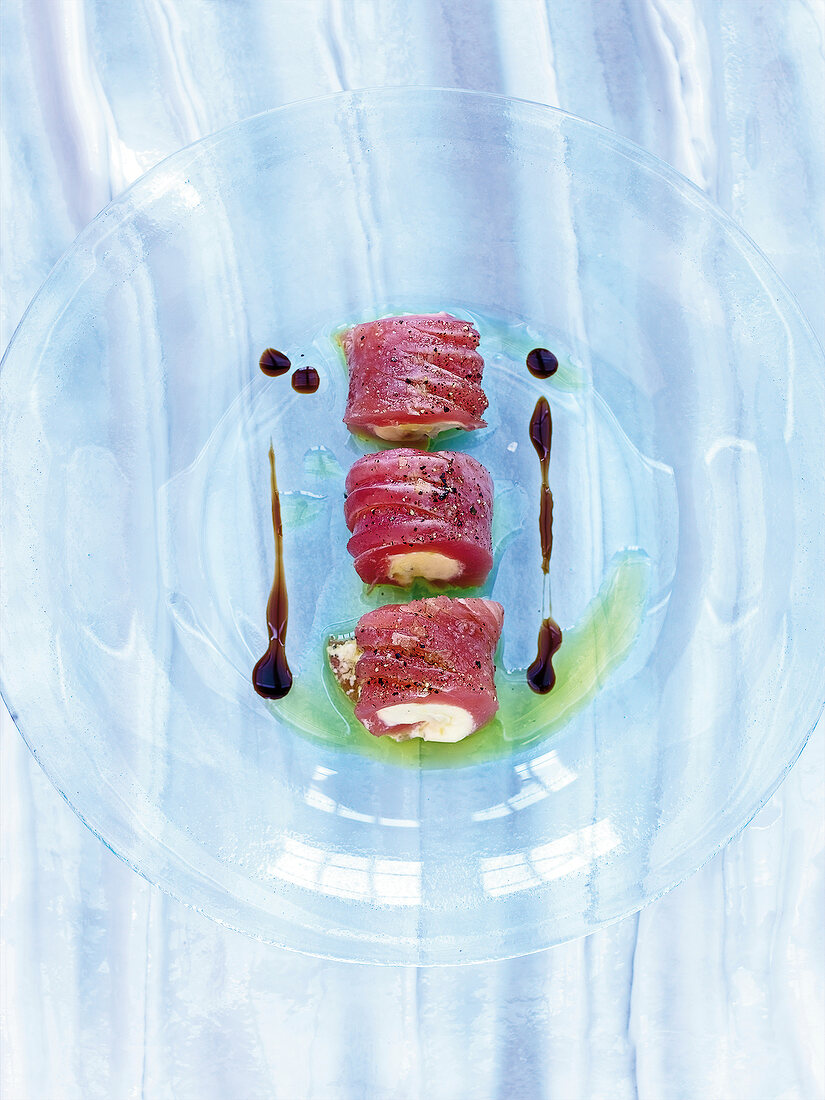 Tuna sashimi stuffed with creme fraiche on glass plate