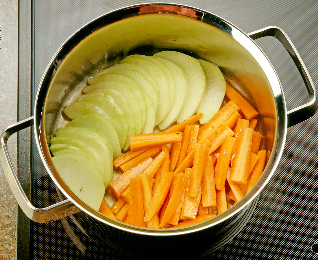 Möhren und Kohlrabi im Kochtopf, close-up.