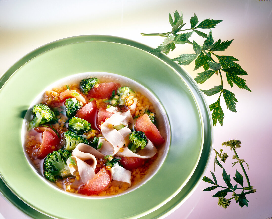 Suppe mit roten Linsen, Brokkoli, Tomaten und Putenbrust-Aufschnitt