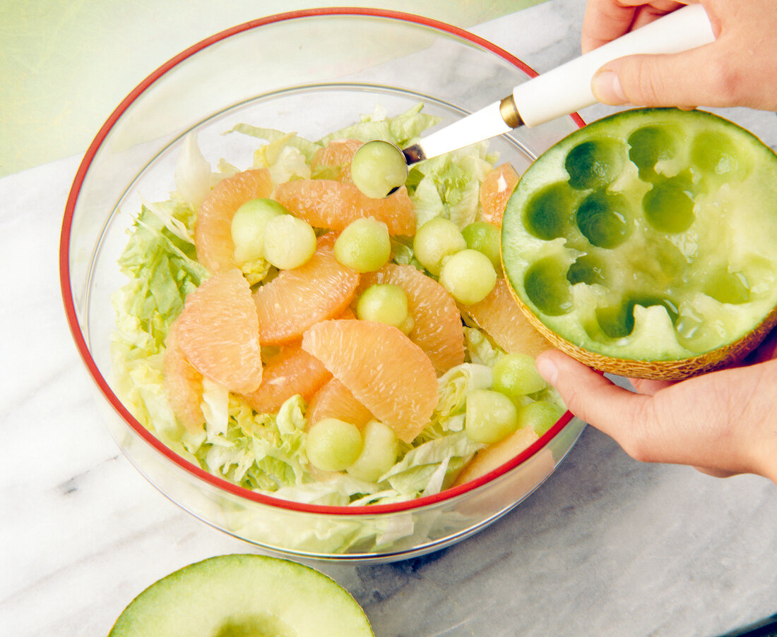 Scooping melon balls in bowl