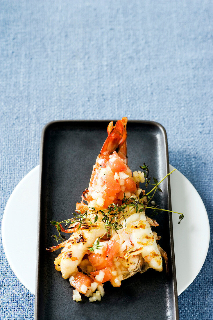 King prawns with spicy tomato salsa and sprigs of thyme on tray