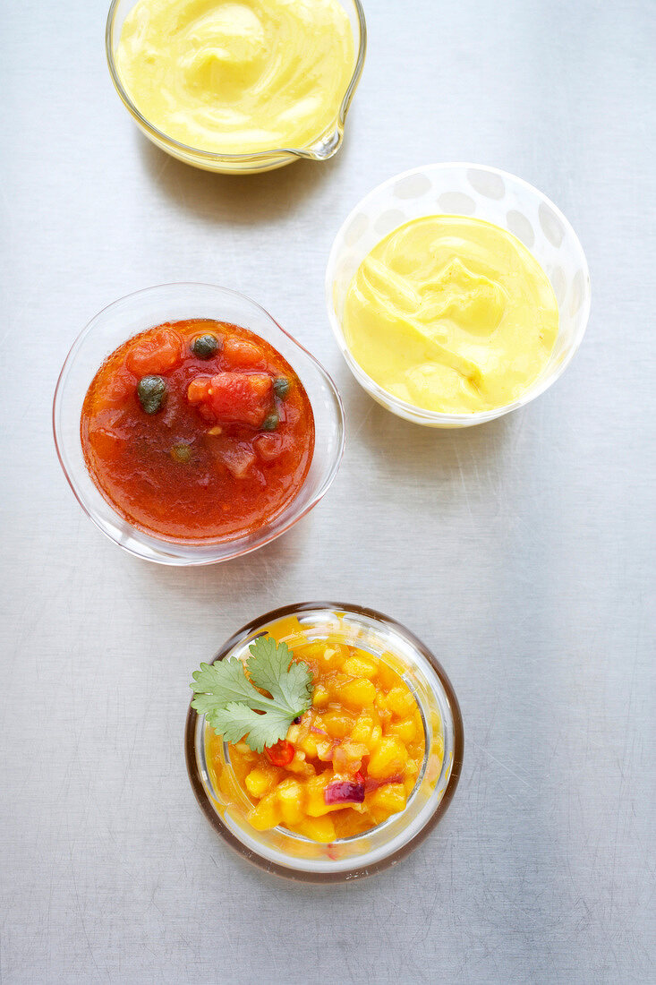 Garlic mayonnaise, tomato and mango chutney and vinaigrette in bowls
