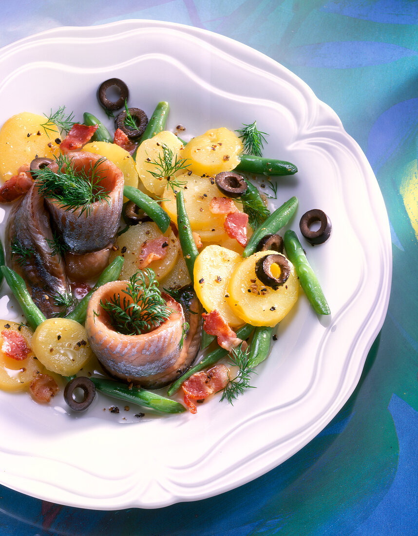 Potato and bean salad with soused herring on plate