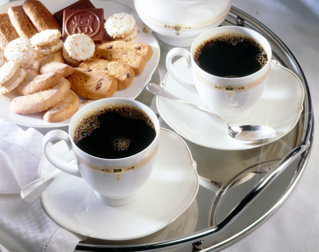 Two cups filled with coffee and pastries on plate
