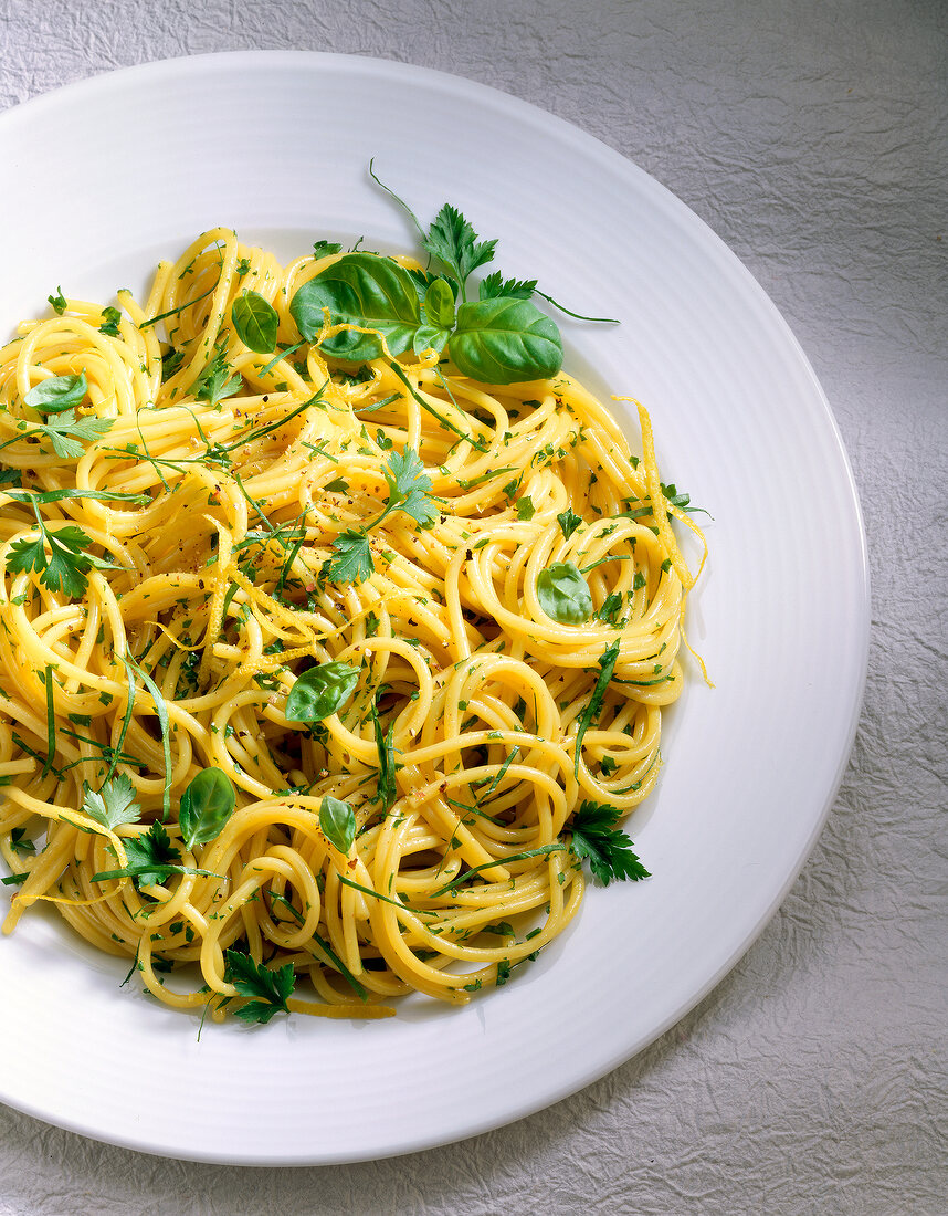 Spaghetti mit Kräutern auf Teller in Weiß