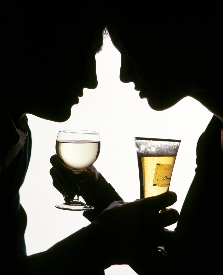 Silhouettes of couple holding glasses of beer and wine