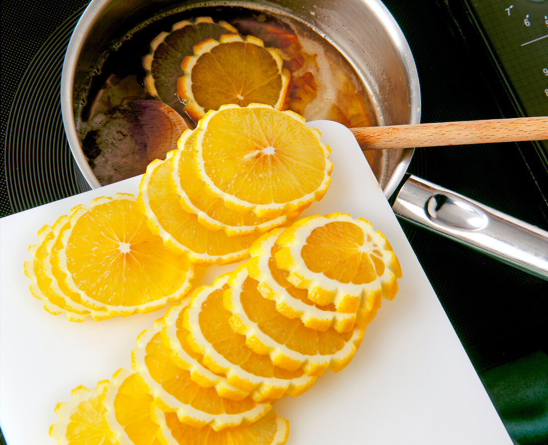 Putting orange slices in heated liquid