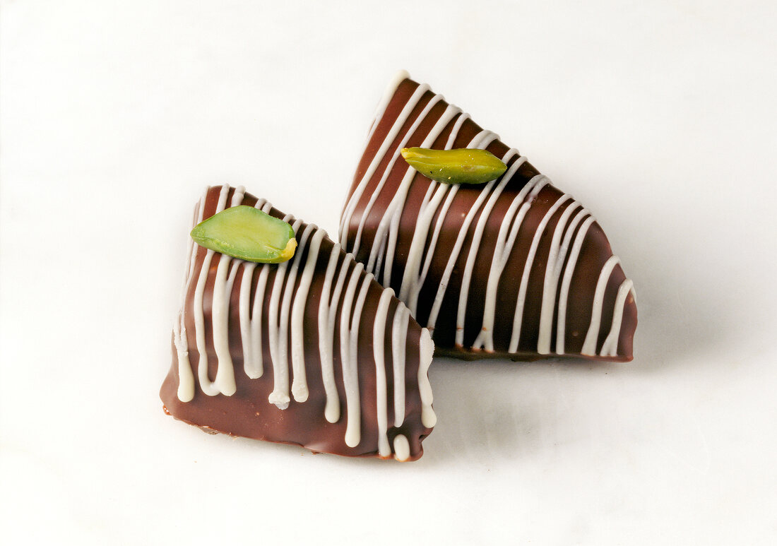Marzipan sweets with pistachios on white background