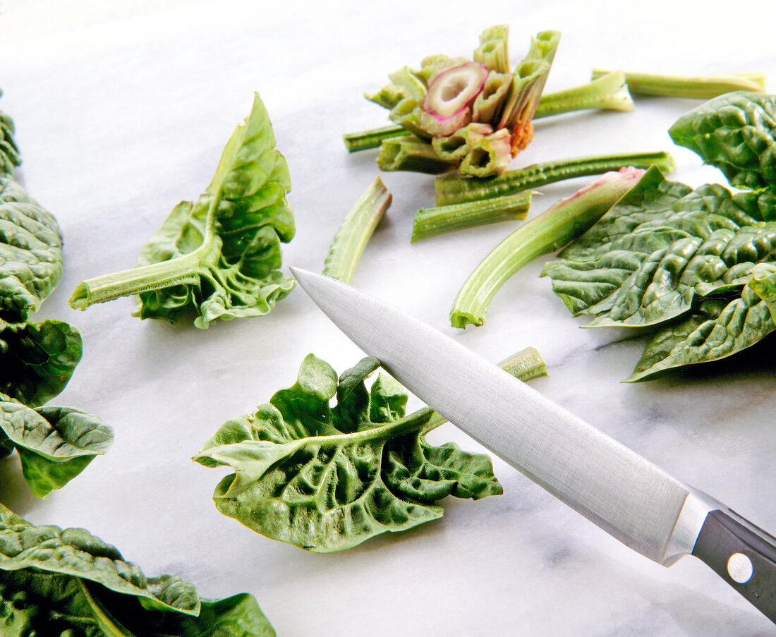 Stems of spinach cut with knife