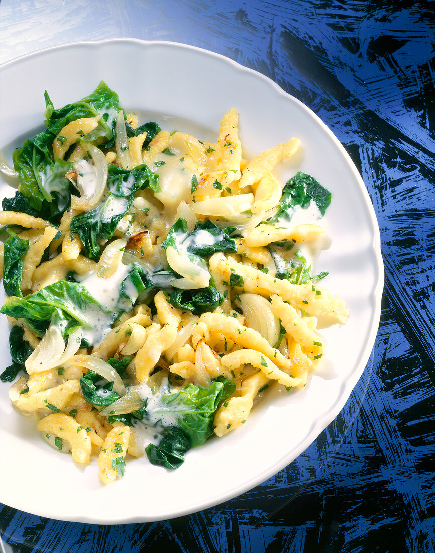 Noodles with spinach and cheese on plate