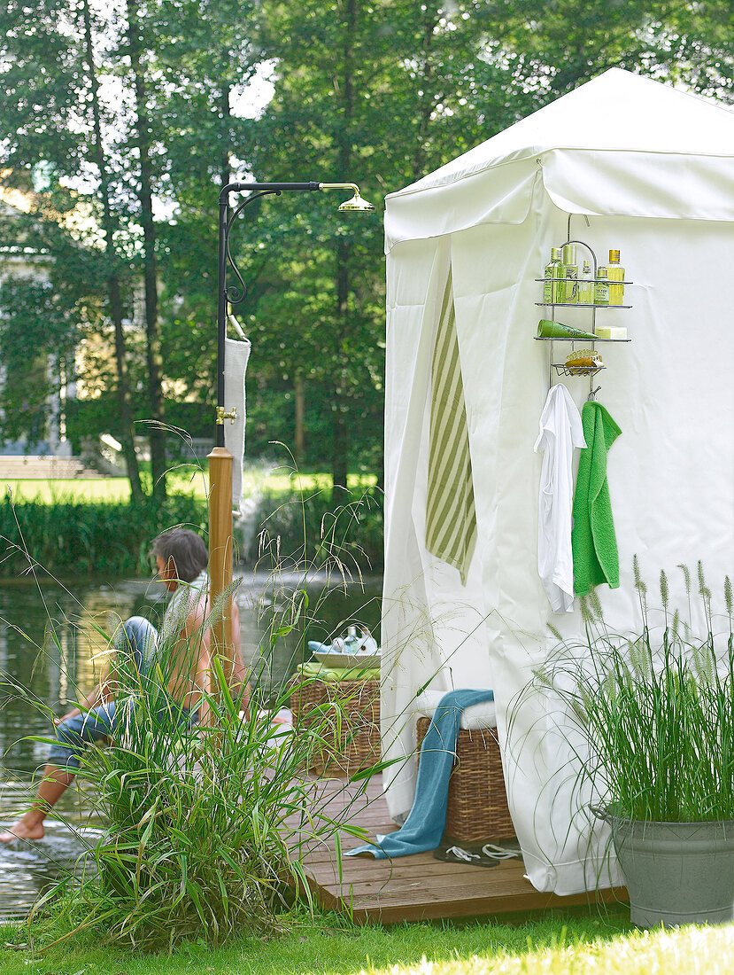 Mobile Badekabine auf einem Steg und eine Gartendusche, direkt am Wasser