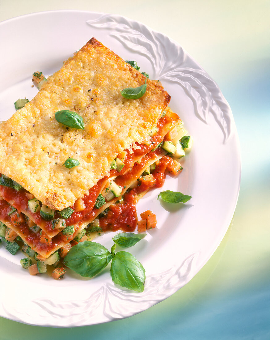 Lasagna with carrots, zucchini, tomatoes and basil in dish