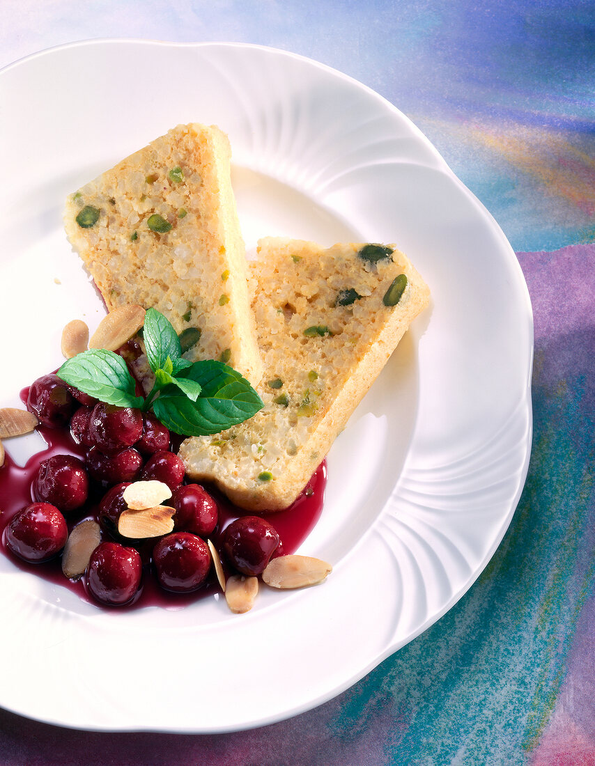 Slices of sweet rice pudding with cherry compote on plate