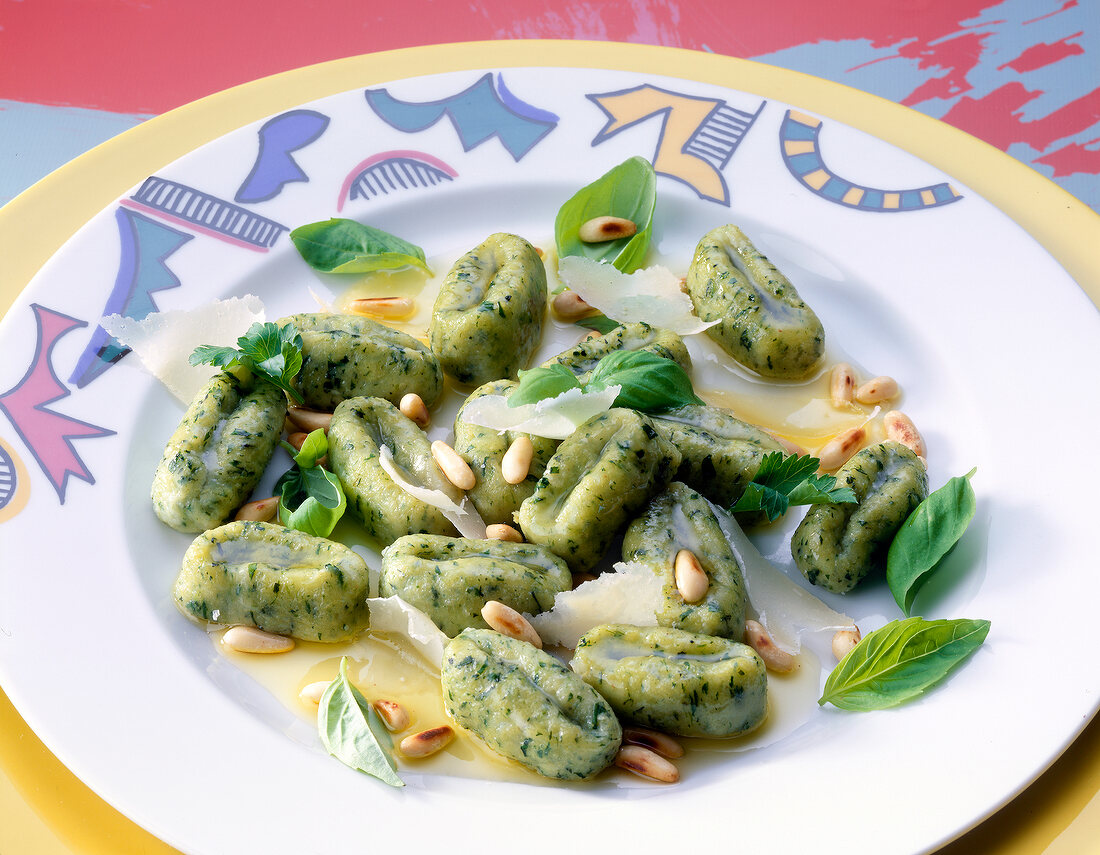 Gnocchi with herbs and pine nuts on plate