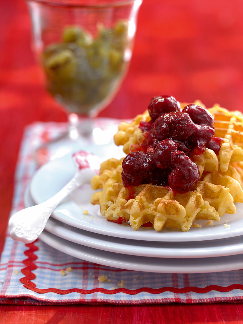 gebackene Waffel mit Kirschen auf einem Teller liegend