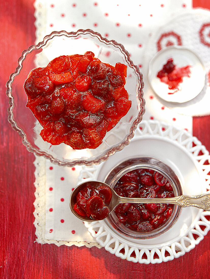 Bowls of strawberry-rhubarb jam and cherry-orange on table