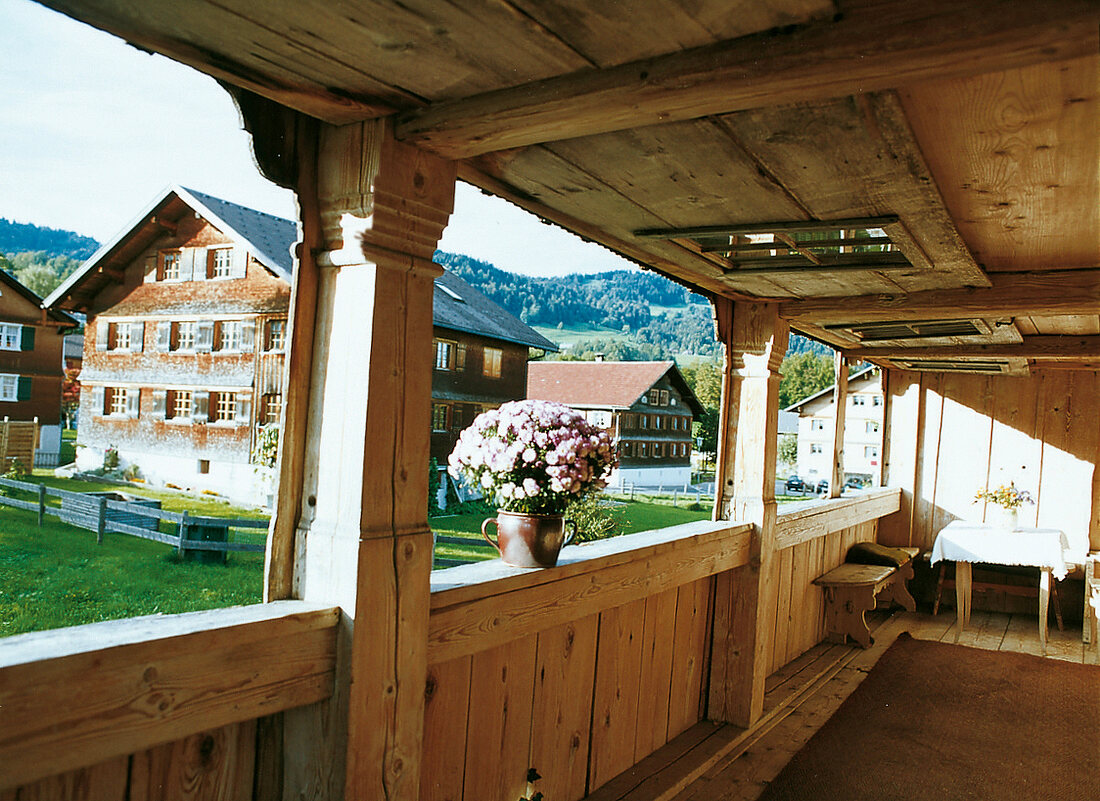 Schopf eines Bregenzerwälder Hauses mit Blumen auf dem Geländer