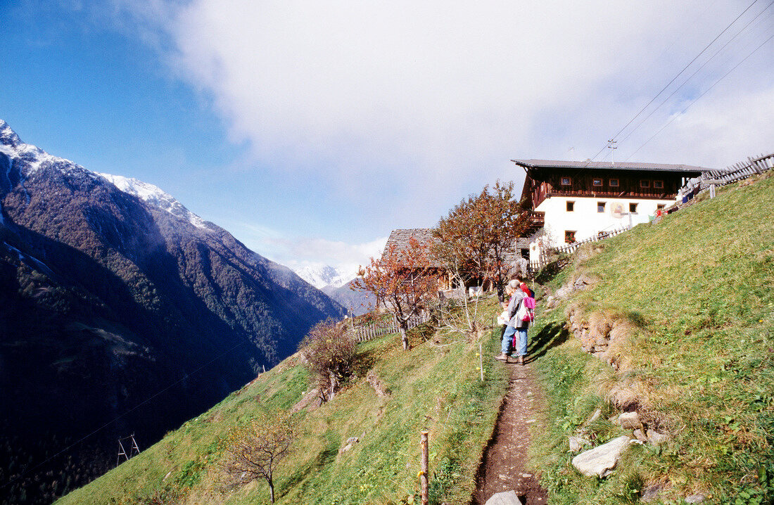 Wanderer auf dem Weg in einen Berghof in Südtirol, Berge, Gipfel