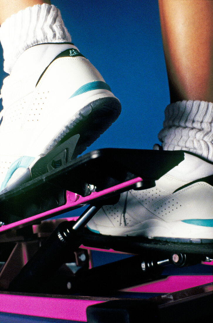 Close-up of human feet exercising on step machine