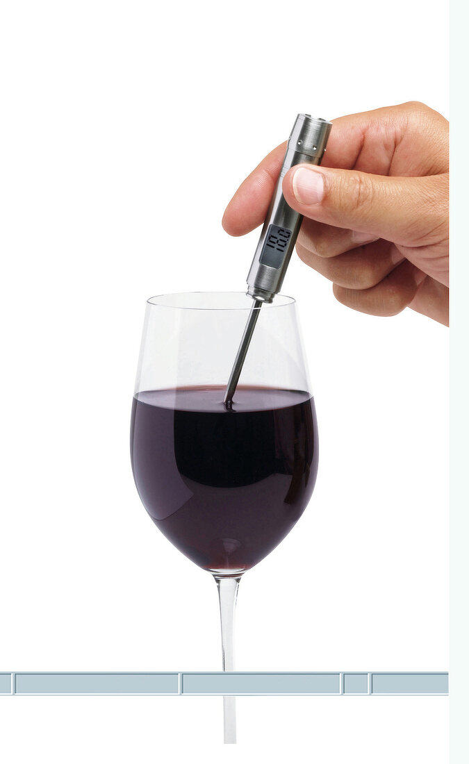 Weinthermometer das in ein Rotweinglas gehalten wird