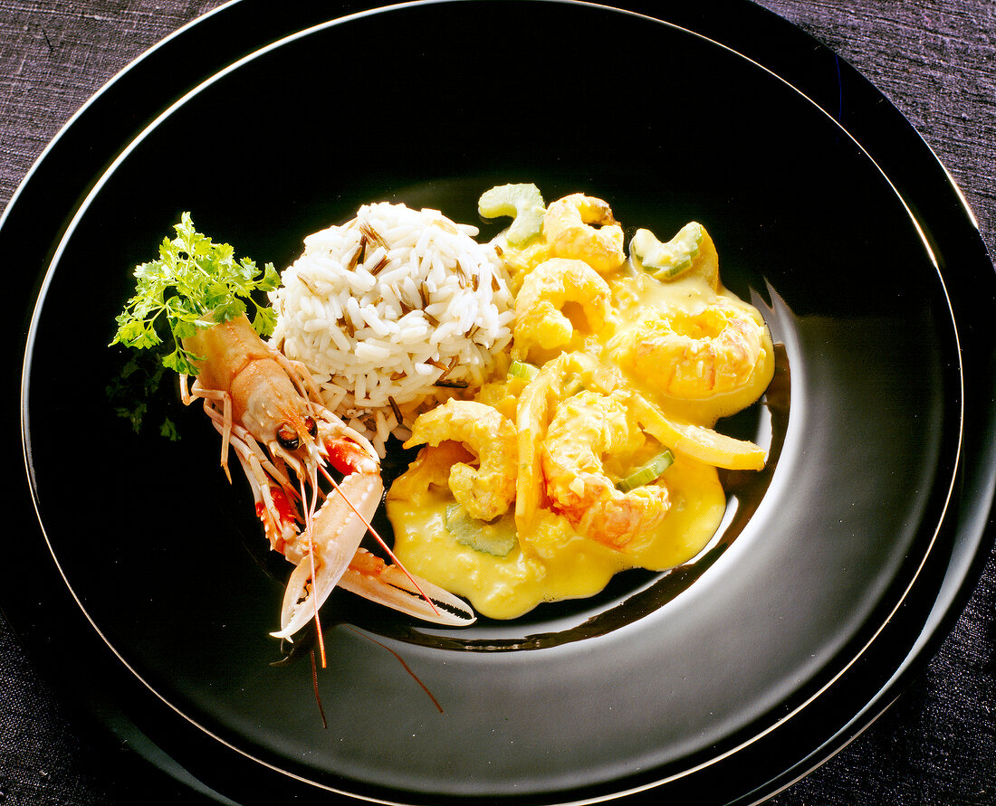 Close-up of scampi sauce with celery, mango, lentils and rice