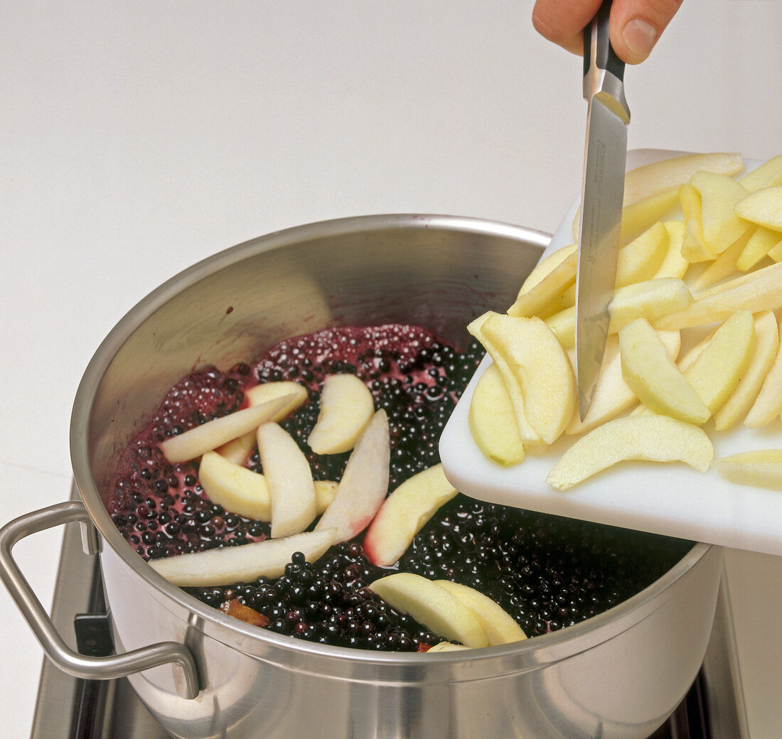 Hand adding slices of apple in pot, step 4