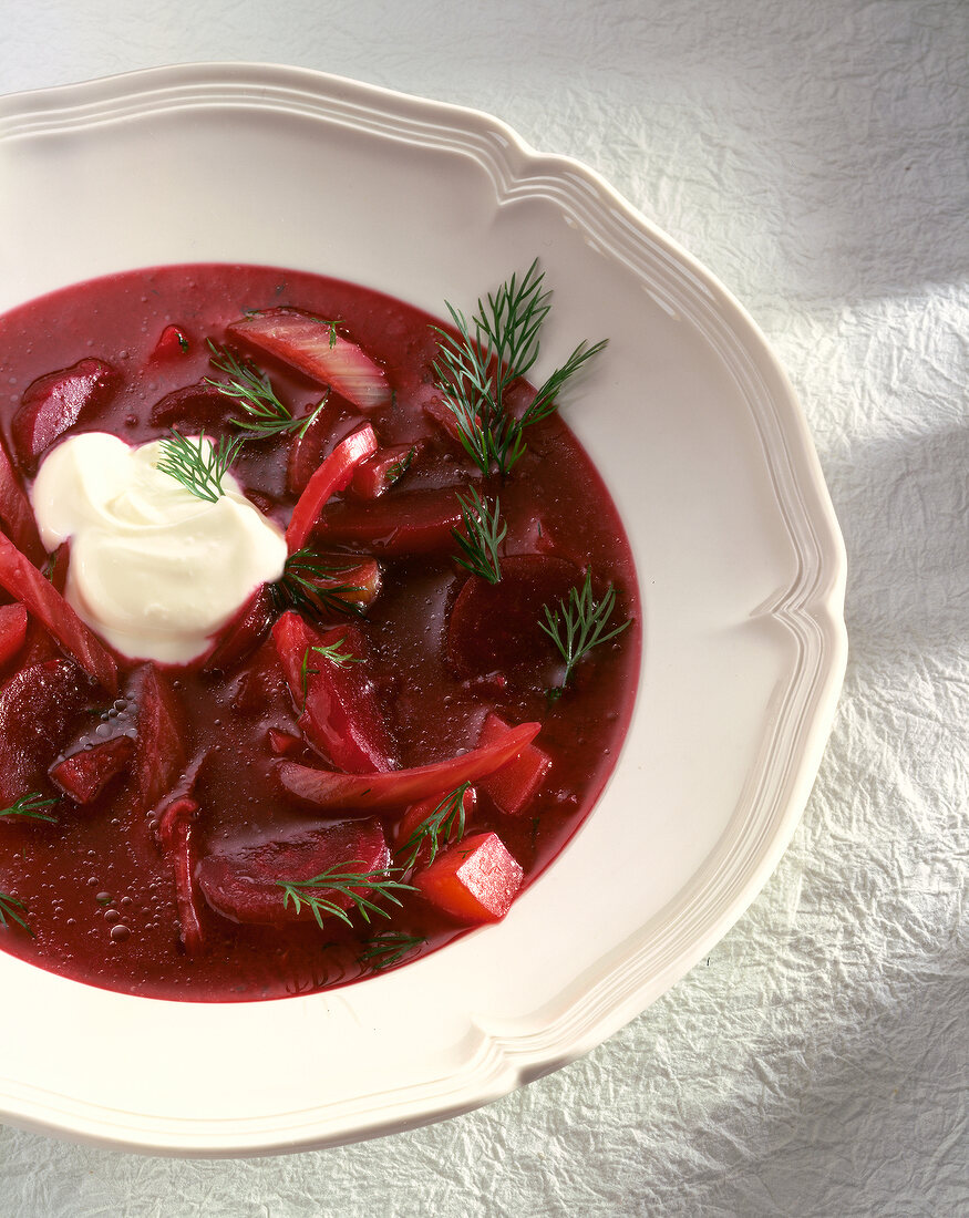 Close-up of beetroot soup with horseradish cream and dill in bowl