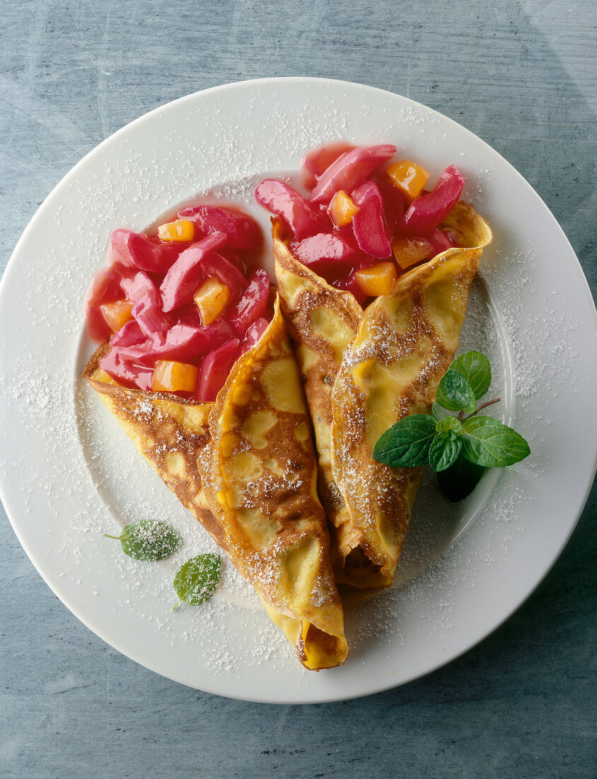 Pancakes with rhubarb and apricot compote on plate