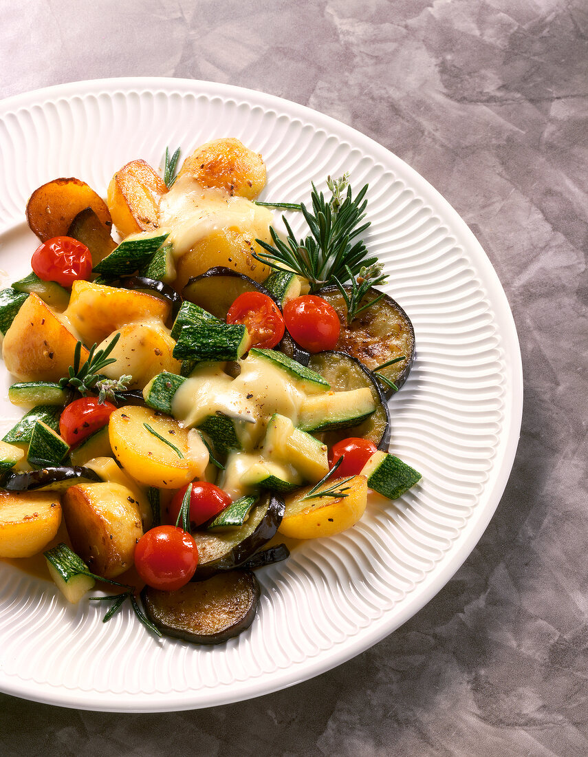 Potato and zucchini with eggplant and cherry tomatoes on plate