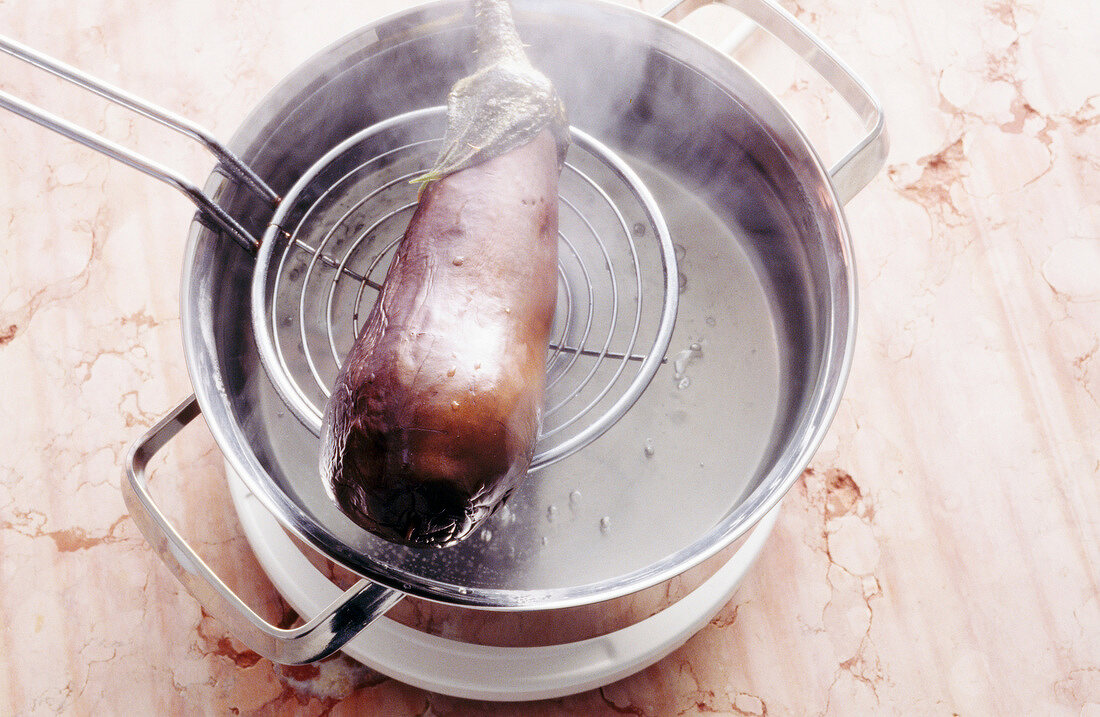 Aubergine mit Schaumkelle aus dem Topf nehmen, Step.