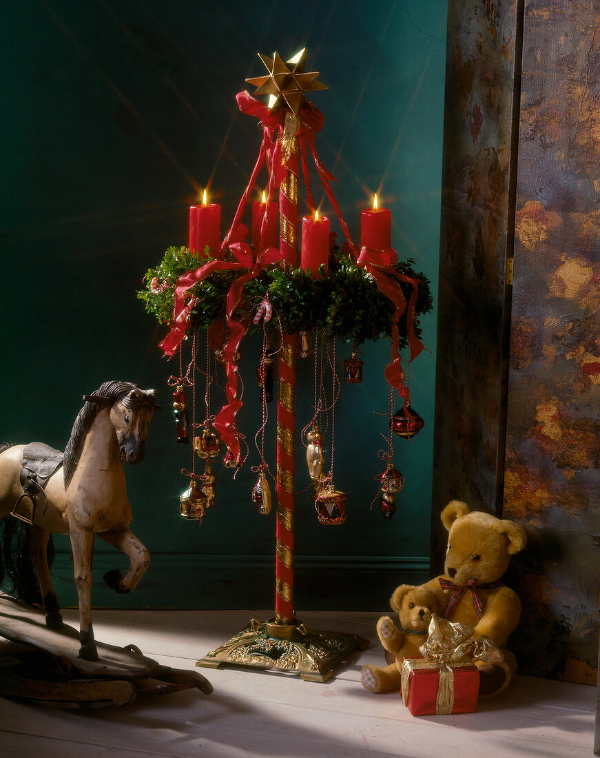 Adventskranz auf Besenstiel, mit roten Bändern, Kerzen und Spielzeug