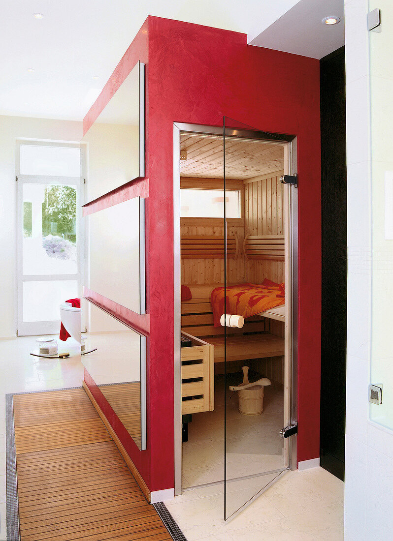 Red sauna room with mirrors and open glass door