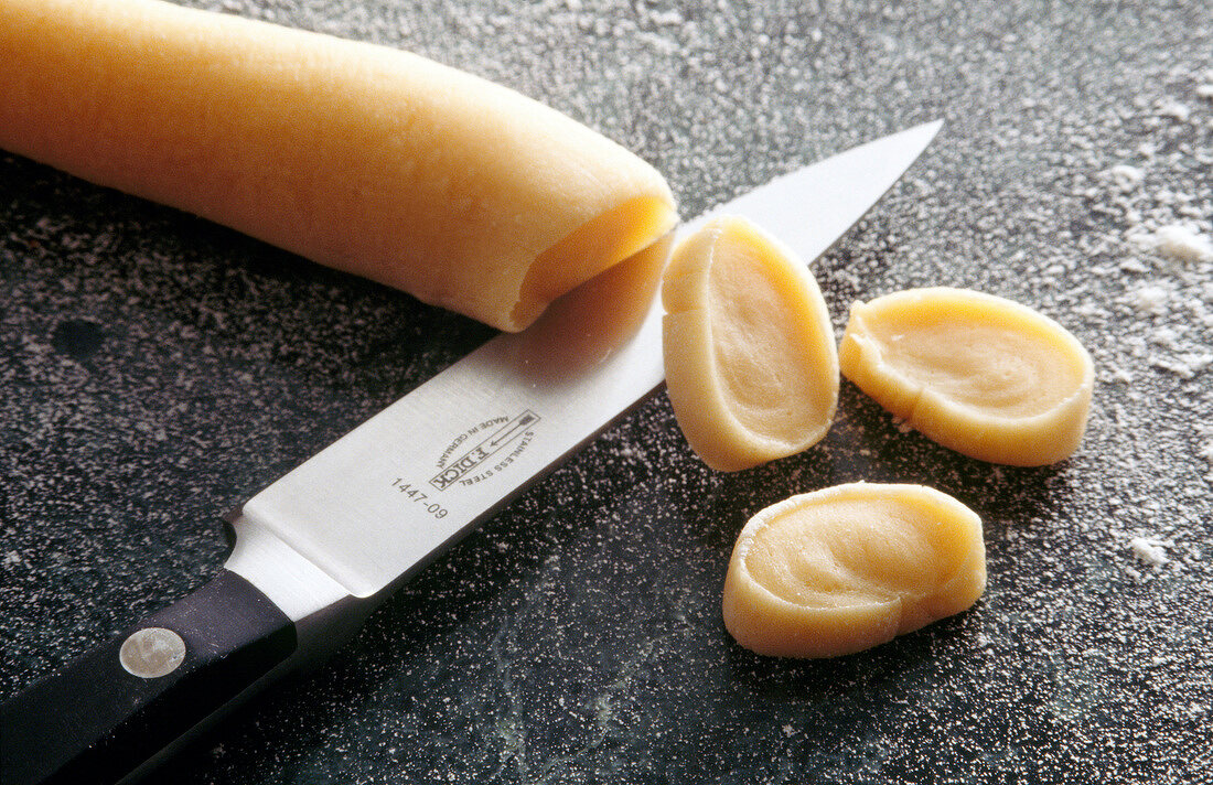 Dough being sliced with kitchen knife, step 1