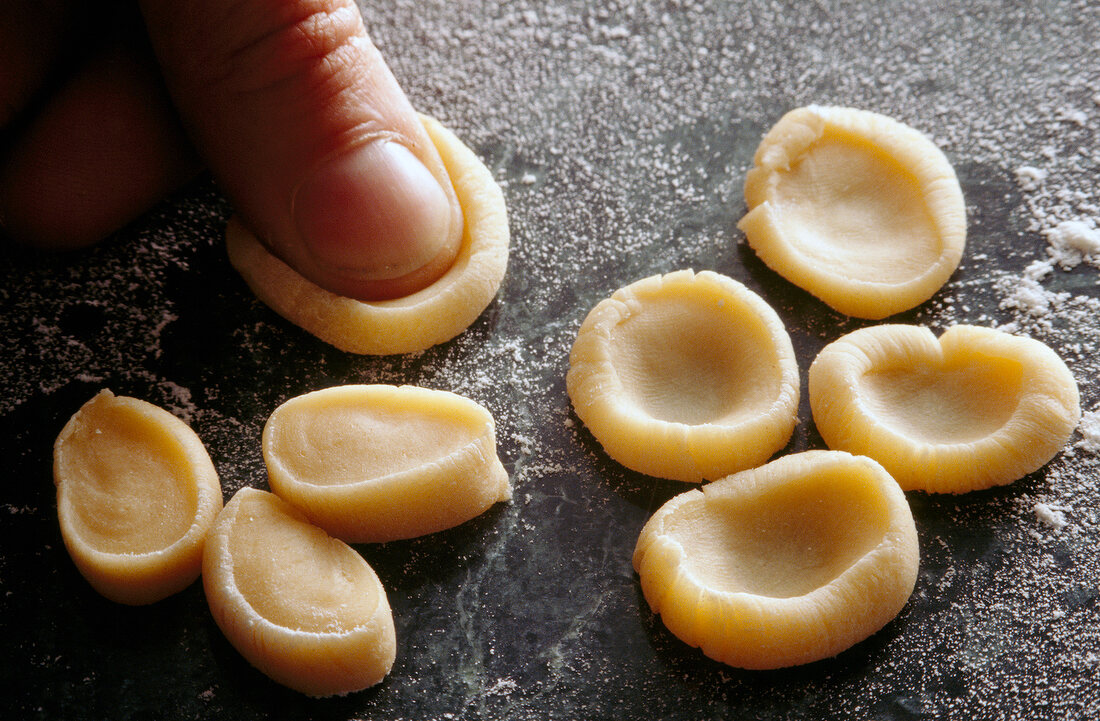 Close-up of person pressing dough slices, step 2