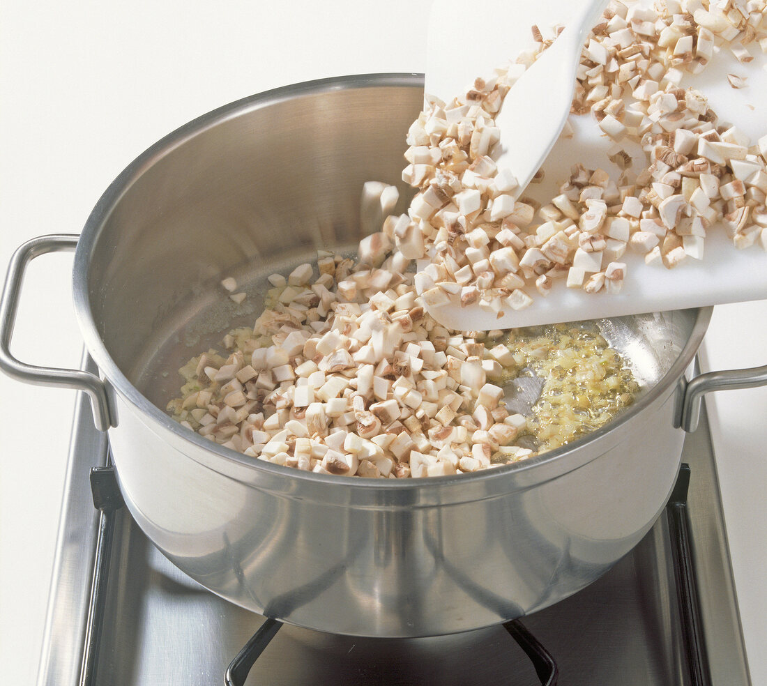 Chopped mushrooms being added in pot, step 4