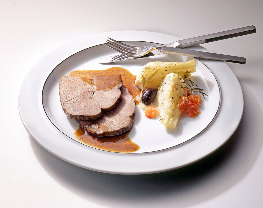 Roasted sheep leg with fennel bone on plate