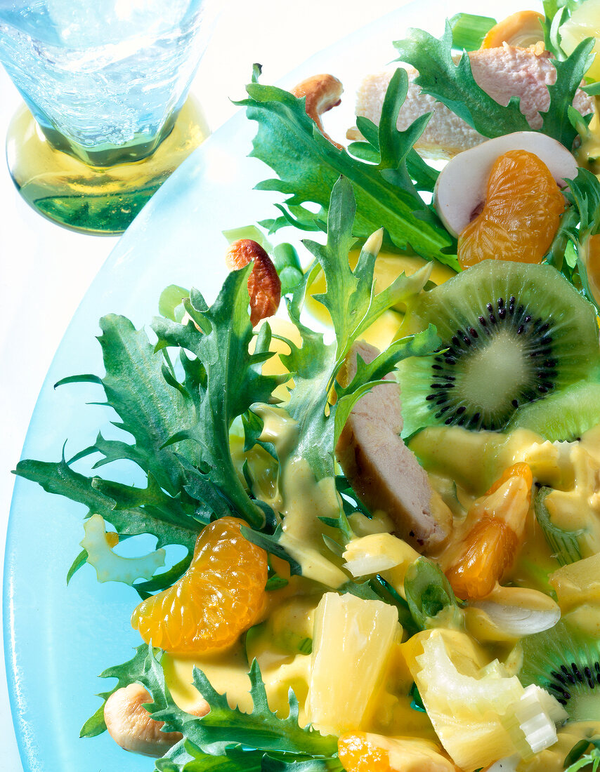 Close-up of chicken salad with kiwi, pineapple, mandarin, oranges, celery and cashew nuts